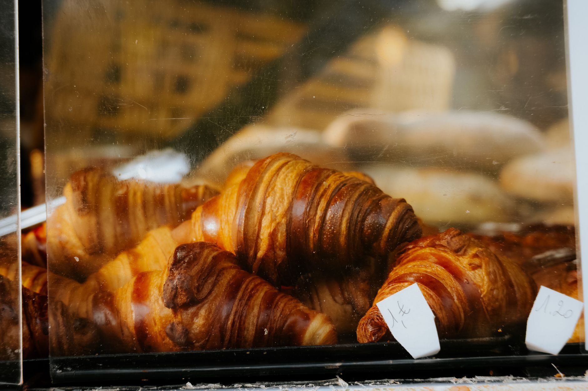 Golden croissants in a warm bakery display case