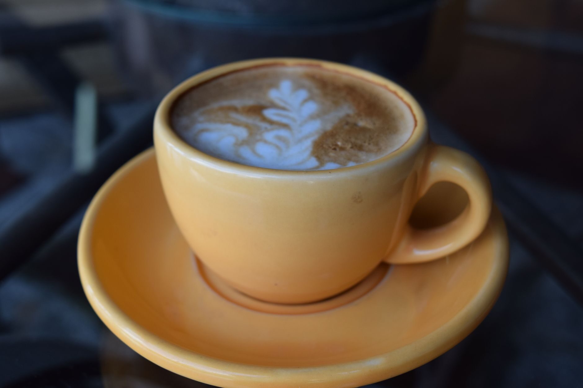 Latte in a copper-glazed ceramic cup and saucer